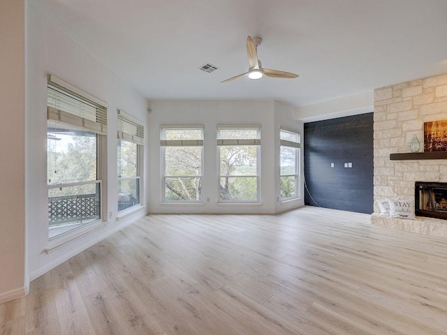 unfurnished living room featuring plenty of natural light, light hardwood / wood-style floors, and a fireplace