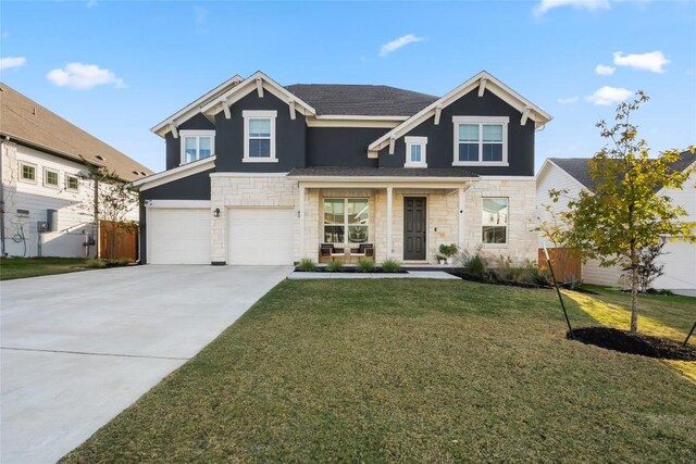 view of front of property featuring covered porch, a front yard, and a garage