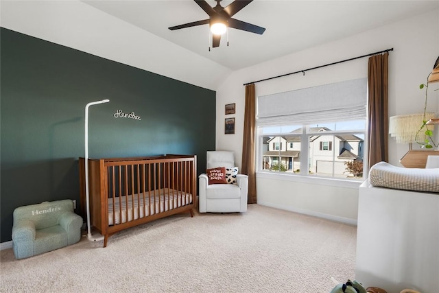 bedroom with lofted ceiling, a nursery area, ceiling fan, and carpet