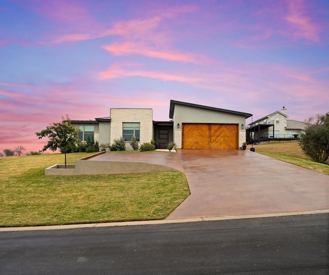 contemporary home featuring a garage and a lawn