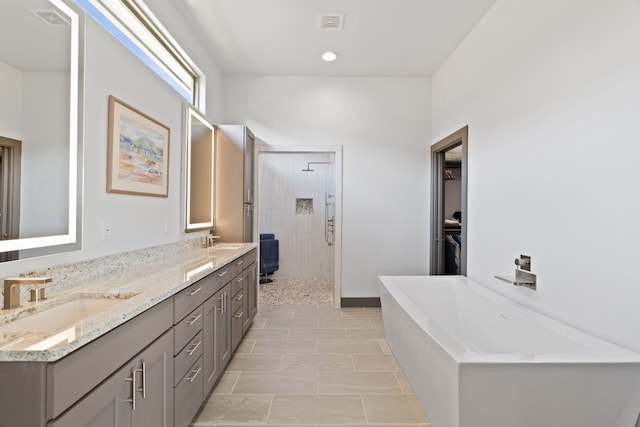 bathroom featuring vanity and independent shower and bath