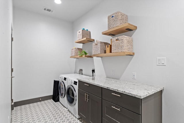 washroom with cabinets and washing machine and clothes dryer