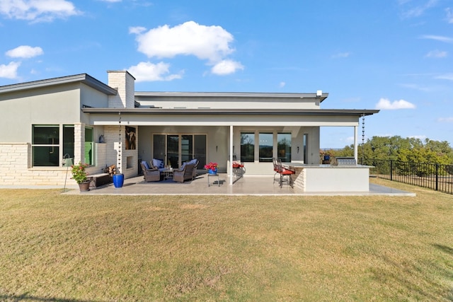 rear view of property featuring outdoor lounge area, a yard, a bar, and an outdoor kitchen