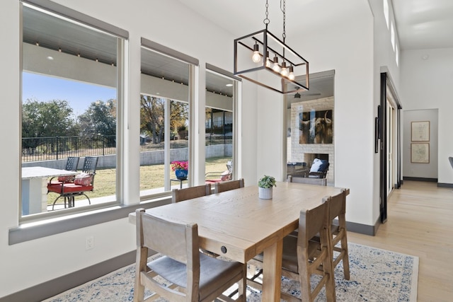 dining area with a notable chandelier, light wood-type flooring, and vaulted ceiling