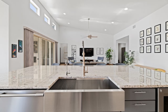 kitchen featuring wine cooler, light stone counters, ceiling fan, and high vaulted ceiling