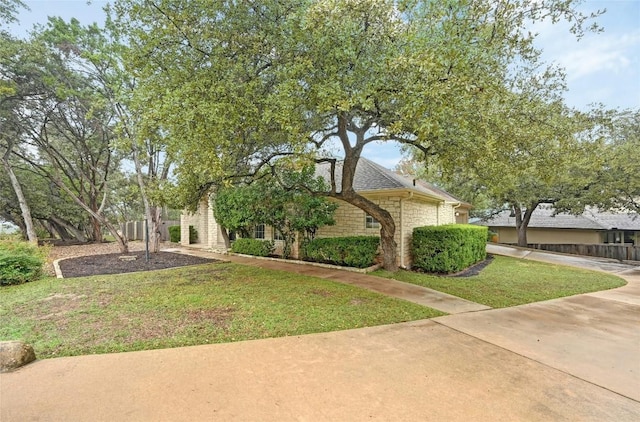 view of front facade with stone siding and a front yard