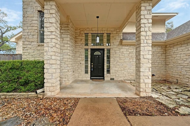 doorway to property featuring roof with shingles