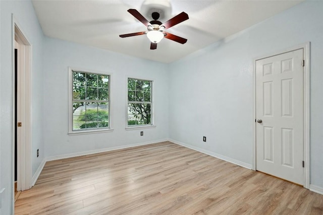 unfurnished room featuring light wood finished floors, baseboards, and a ceiling fan