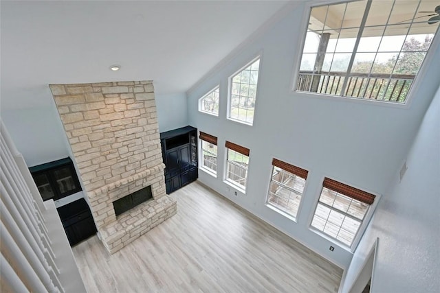 unfurnished living room with wood finished floors and a towering ceiling