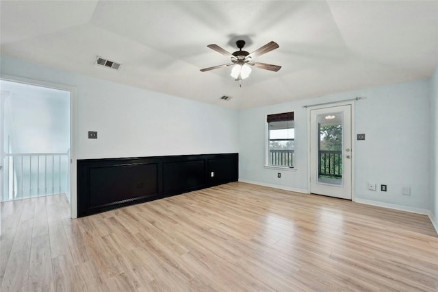 spare room featuring light wood-style flooring, a ceiling fan, visible vents, and baseboards