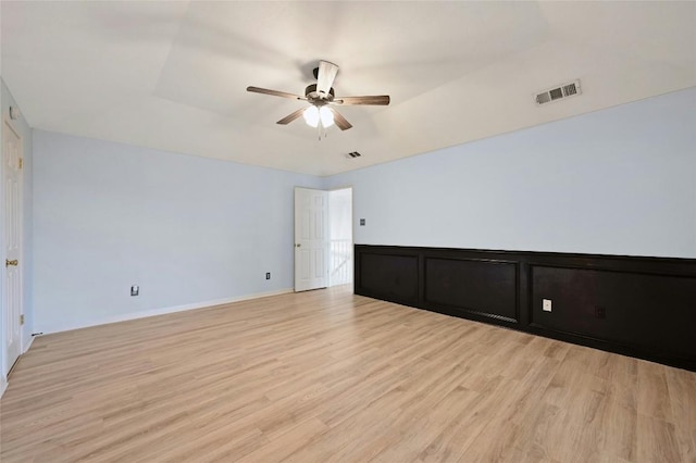 empty room with light wood-style floors, visible vents, and ceiling fan