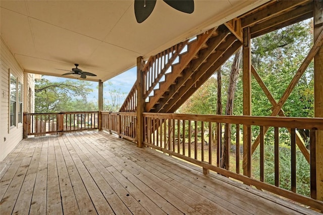 wooden deck featuring a ceiling fan and stairs