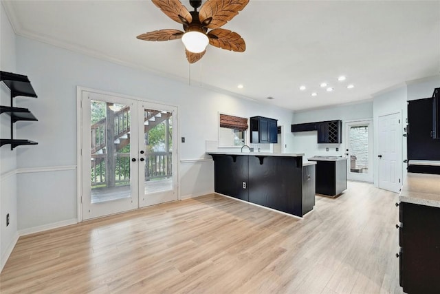 kitchen featuring a peninsula, light countertops, dark cabinets, and french doors