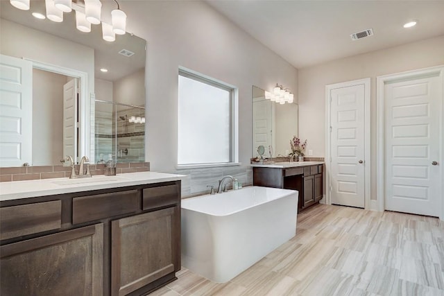 bathroom with hardwood / wood-style flooring, vanity, and independent shower and bath