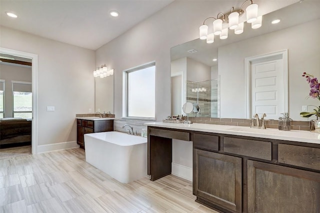 bathroom with vanity, independent shower and bath, and a wealth of natural light