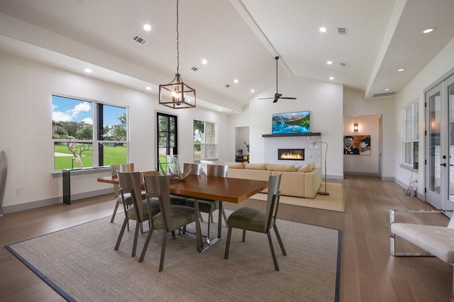 dining room featuring ceiling fan, light wood-type flooring, and high vaulted ceiling