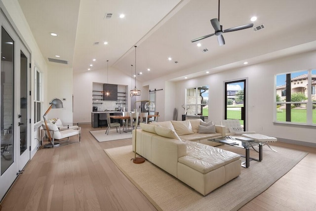 living room featuring ceiling fan, light hardwood / wood-style floors, and high vaulted ceiling