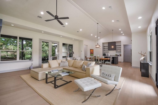 living room with ceiling fan, light hardwood / wood-style floors, high vaulted ceiling, and french doors