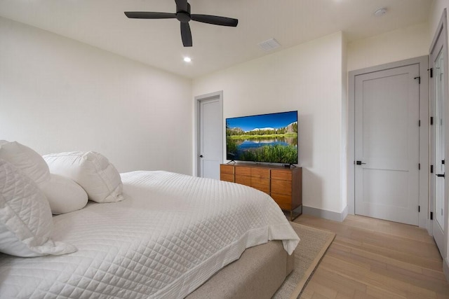 bedroom with light hardwood / wood-style floors and ceiling fan