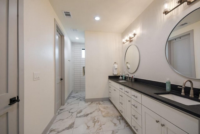 bathroom featuring a shower with door and vanity