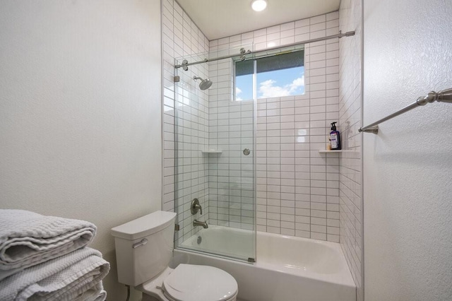 bathroom featuring combined bath / shower with glass door and toilet