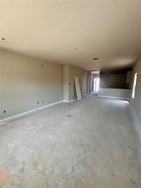 224 Lazy Lizzy Rd, Jarrell, TX 76537 - unfurnished living room featuring concrete floors and baseboards