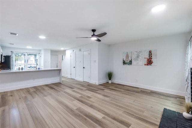 unfurnished living room featuring ceiling fan and light hardwood / wood-style flooring