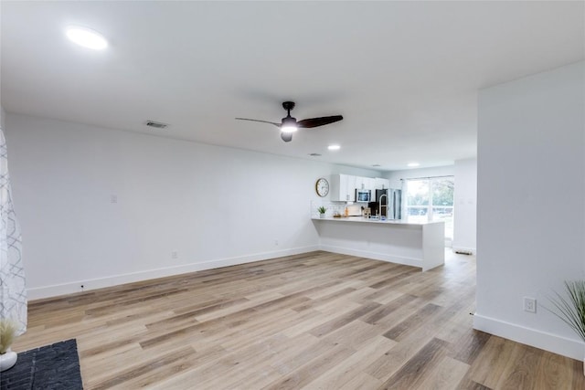 unfurnished living room featuring ceiling fan and light hardwood / wood-style floors