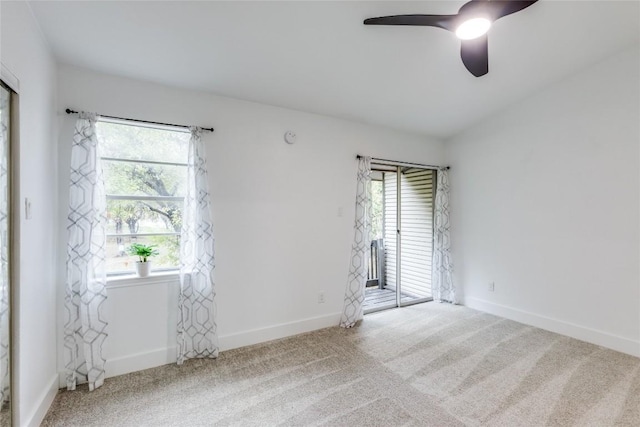 carpeted empty room featuring a wealth of natural light and ceiling fan