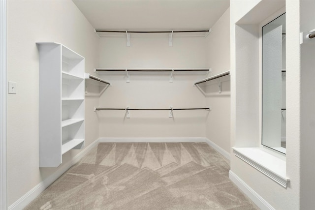 walk in closet with light colored carpet