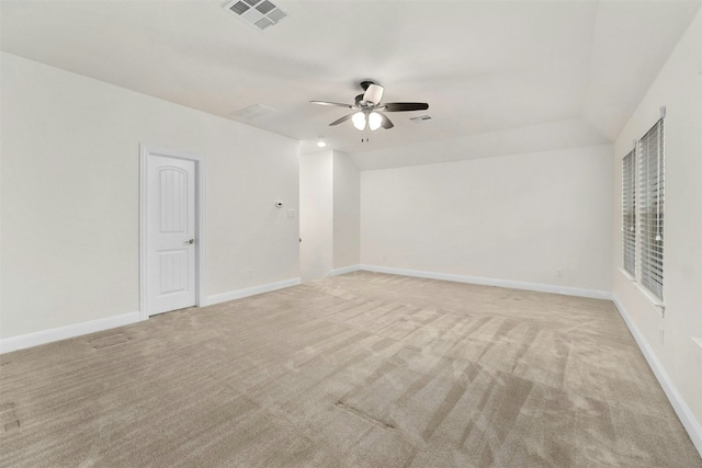 spare room featuring light carpet, ceiling fan, and lofted ceiling