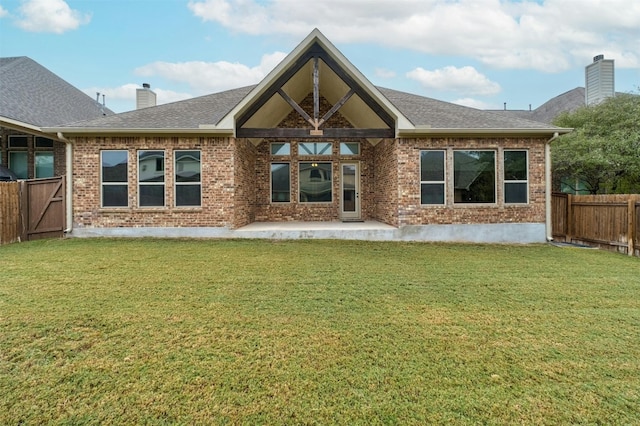 rear view of house featuring a patio area and a yard