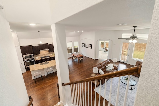 staircase with ceiling fan, sink, lofted ceiling, and hardwood / wood-style flooring