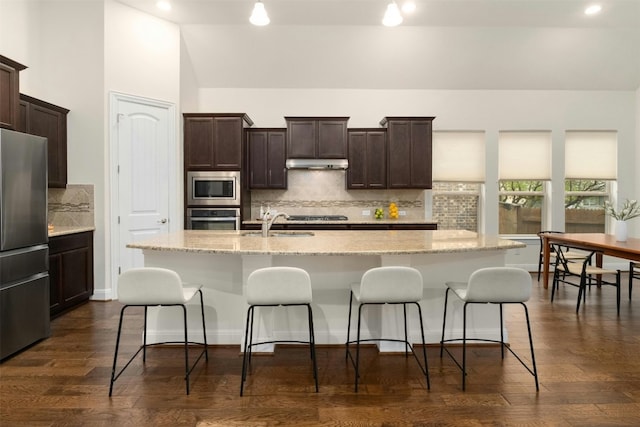 kitchen featuring a center island with sink, dark hardwood / wood-style floors, and appliances with stainless steel finishes