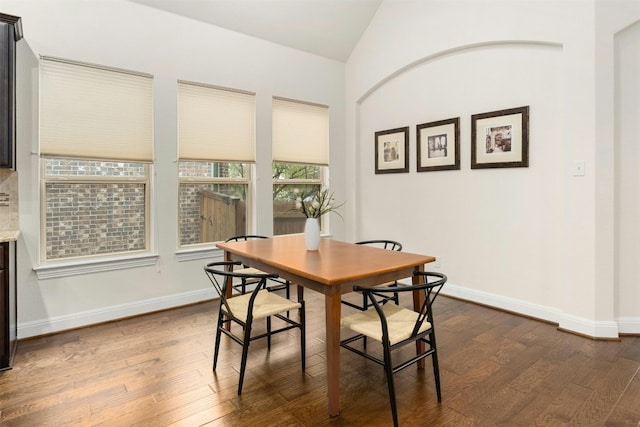 dining area with dark hardwood / wood-style floors and lofted ceiling