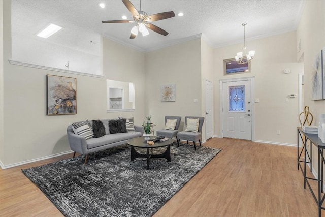 living room featuring hardwood / wood-style flooring, crown molding, a towering ceiling, and a textured ceiling