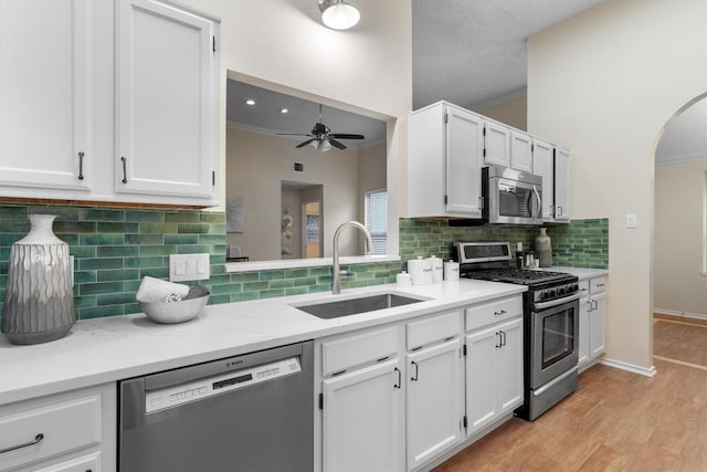 kitchen with sink, white cabinets, a textured ceiling, and appliances with stainless steel finishes