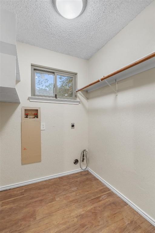 washroom featuring washer hookup, a textured ceiling, gas dryer hookup, electric dryer hookup, and hardwood / wood-style floors