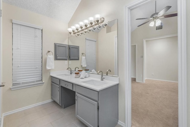 bathroom featuring ceiling fan, tile patterned floors, a textured ceiling, lofted ceiling, and vanity