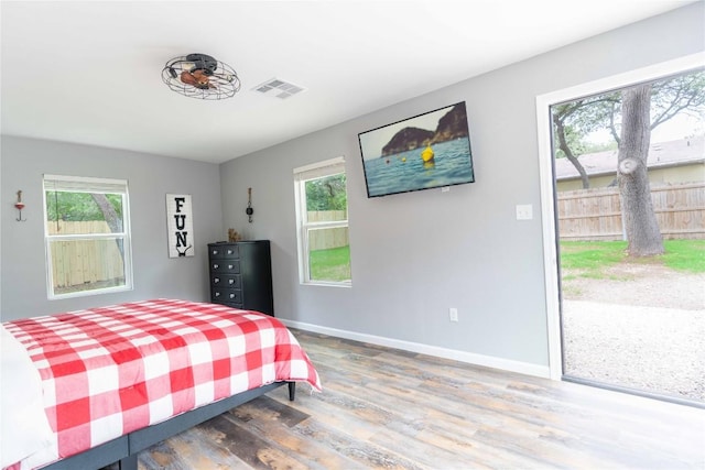 bedroom with wood-type flooring and multiple windows