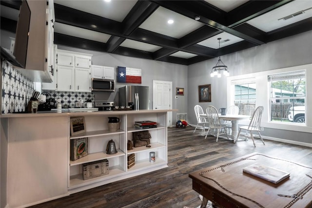 kitchen featuring white cabinetry, beamed ceiling, stainless steel appliances, and decorative light fixtures