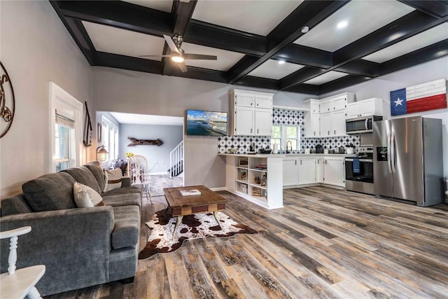 living room featuring coffered ceiling, sink, hardwood / wood-style flooring, ceiling fan, and beam ceiling