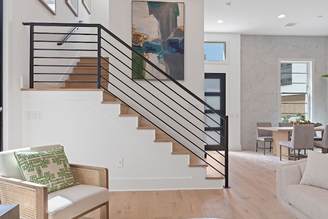 staircase with wood-type flooring and plenty of natural light