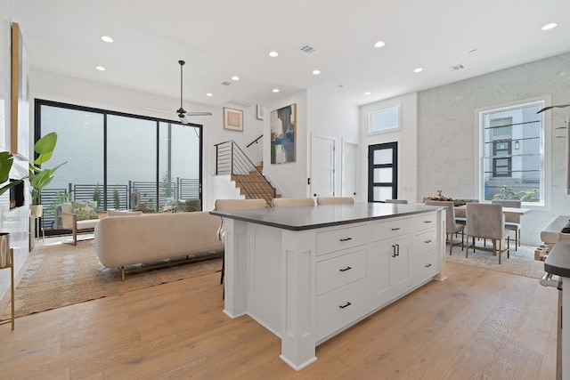 kitchen with a center island, ceiling fan, light hardwood / wood-style floors, and white cabinetry