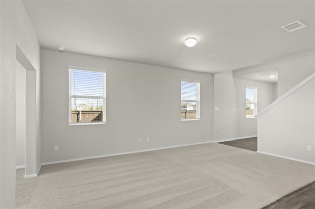 carpeted spare room featuring a wealth of natural light