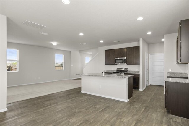 kitchen featuring sink, stainless steel appliances, dark hardwood / wood-style flooring, a center island with sink, and dark brown cabinets