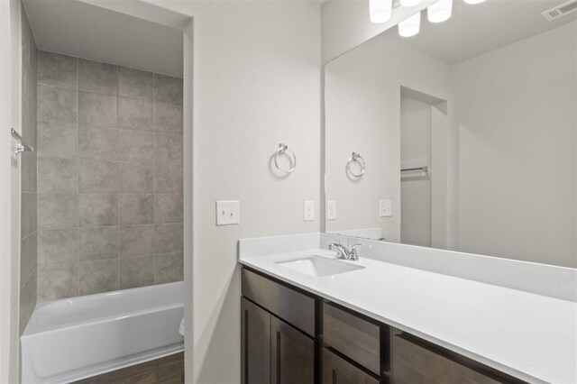 bathroom featuring vanity and tiled shower / bath