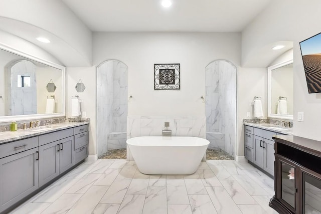 bathroom with vanity, shower with separate bathtub, and tile walls