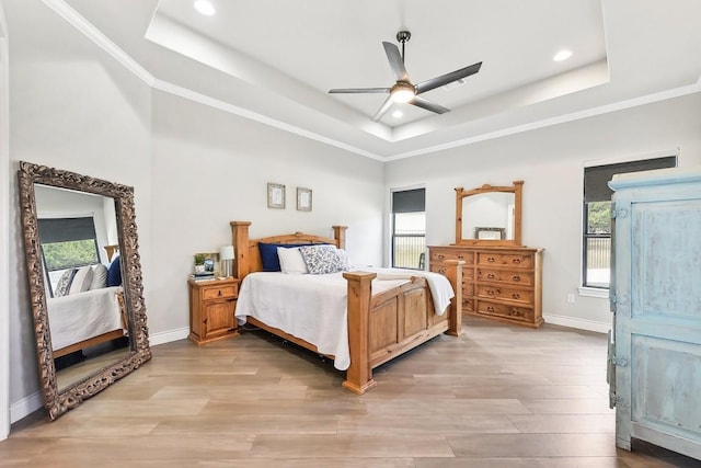 bedroom featuring a tray ceiling, multiple windows, and ceiling fan