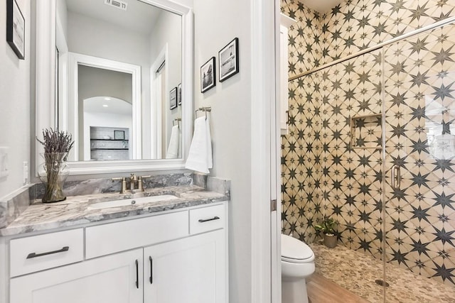 bathroom featuring hardwood / wood-style floors, vanity, toilet, tile walls, and an enclosed shower